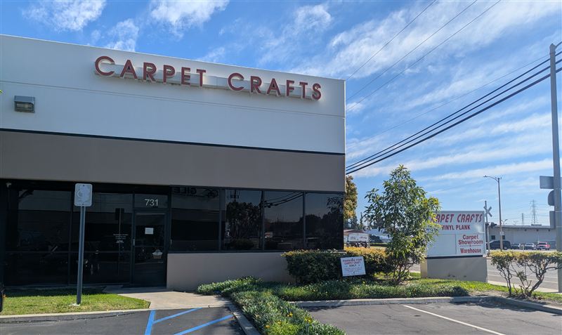 Carpet Crafts showroom entrance with signage and parking